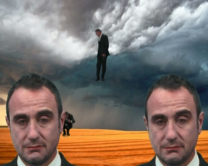 Commedia — Teste: figura sospesa tra due volti giganti, video Taraborrelli