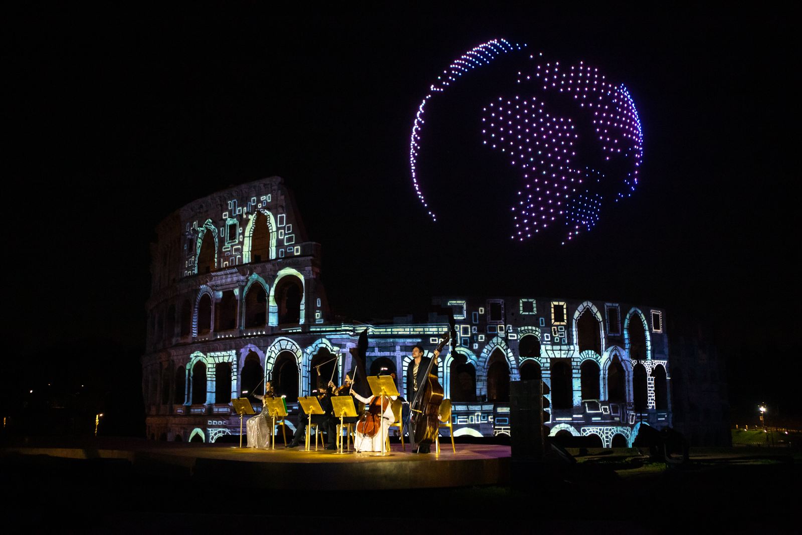 Musicians performing at the Colosseum with drone globe in the sky