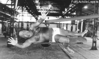 Graal - foto Achille Lepera, uomo orizzontale su intelaiatura metallica, capannone industriale Officine Molliconi 2000