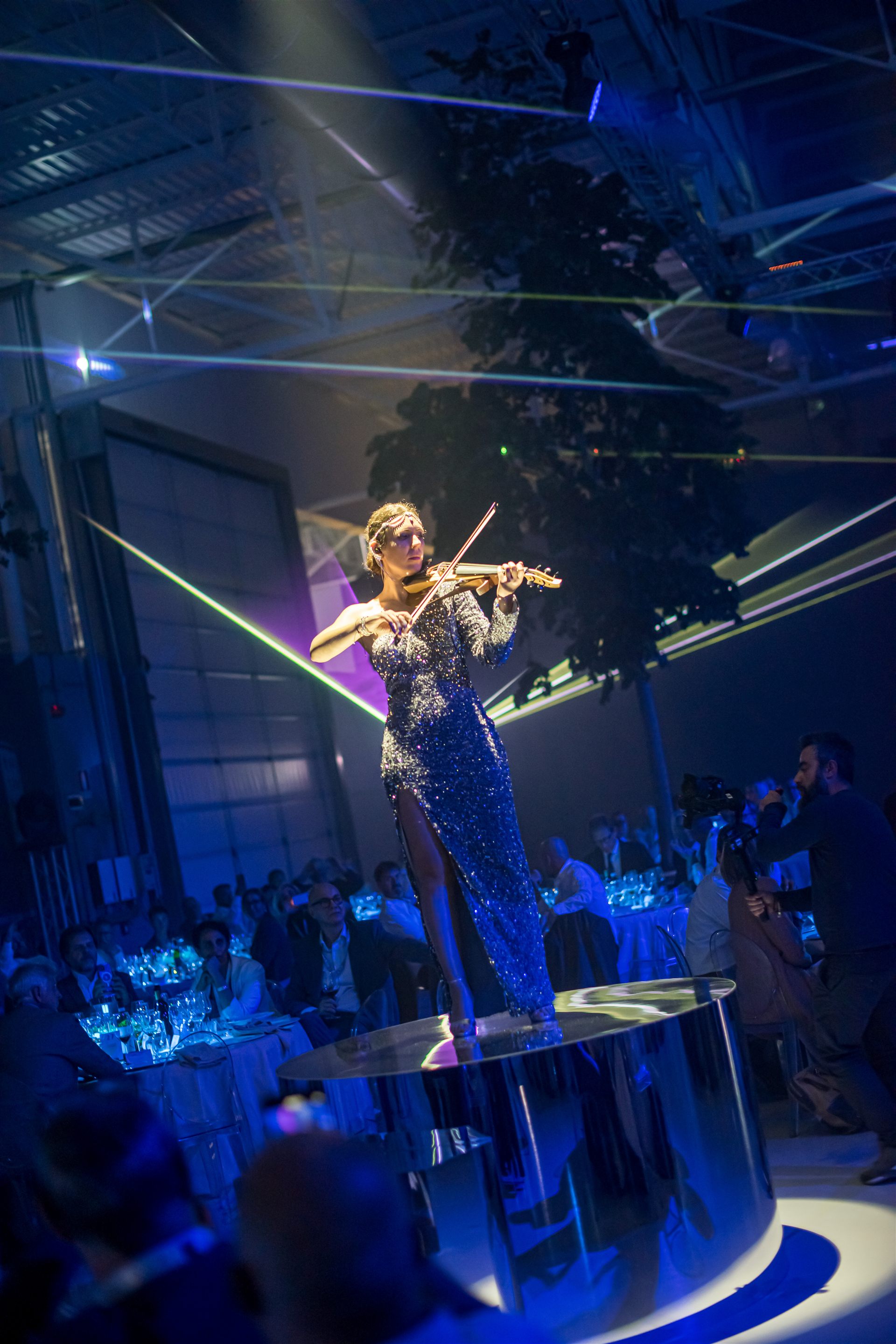Iveco Connecting the Dots — violinista su palco specchio con fasci laser e albero