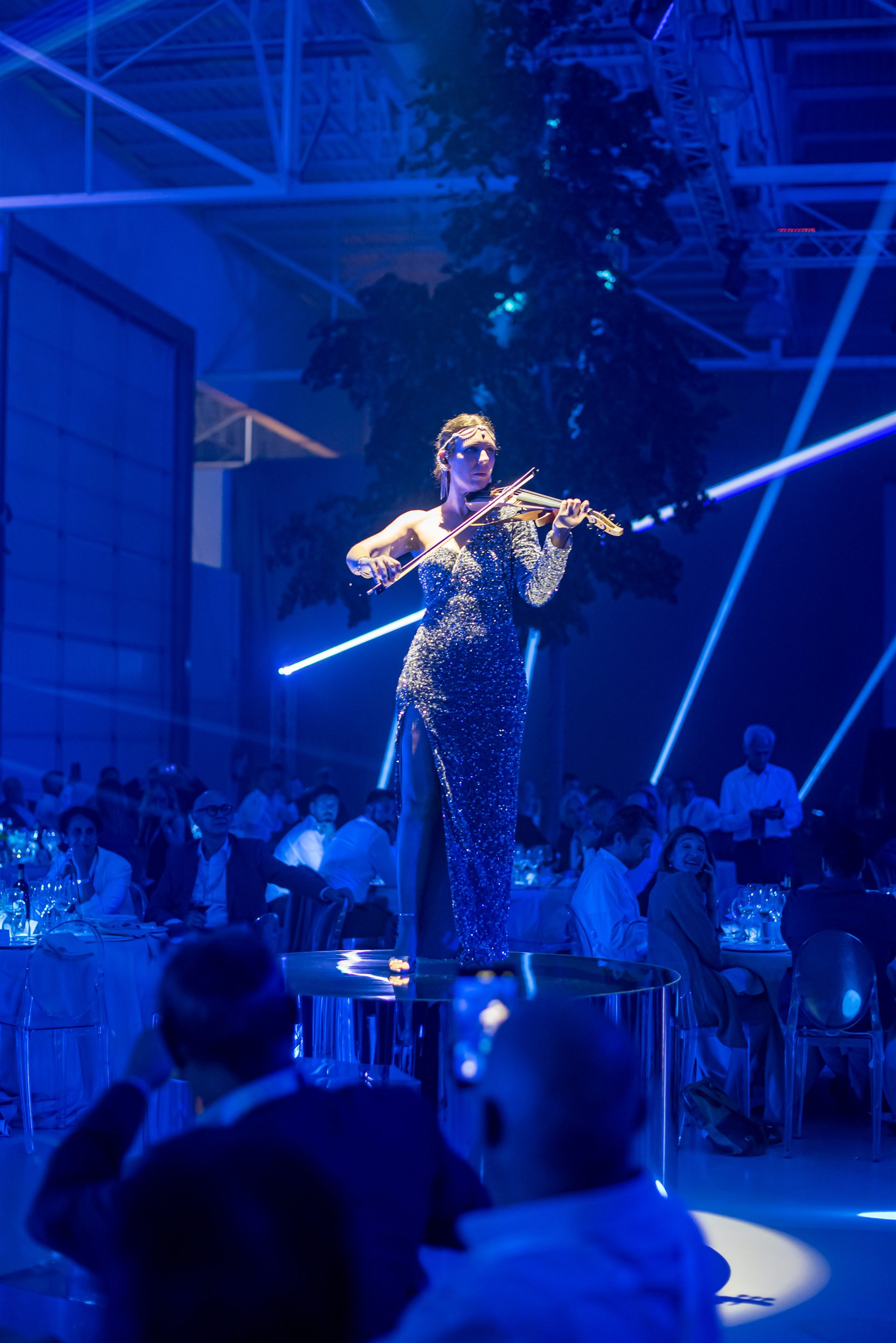 Iveco Connecting the Dots — violinista con laser blu e chioma dell'albero