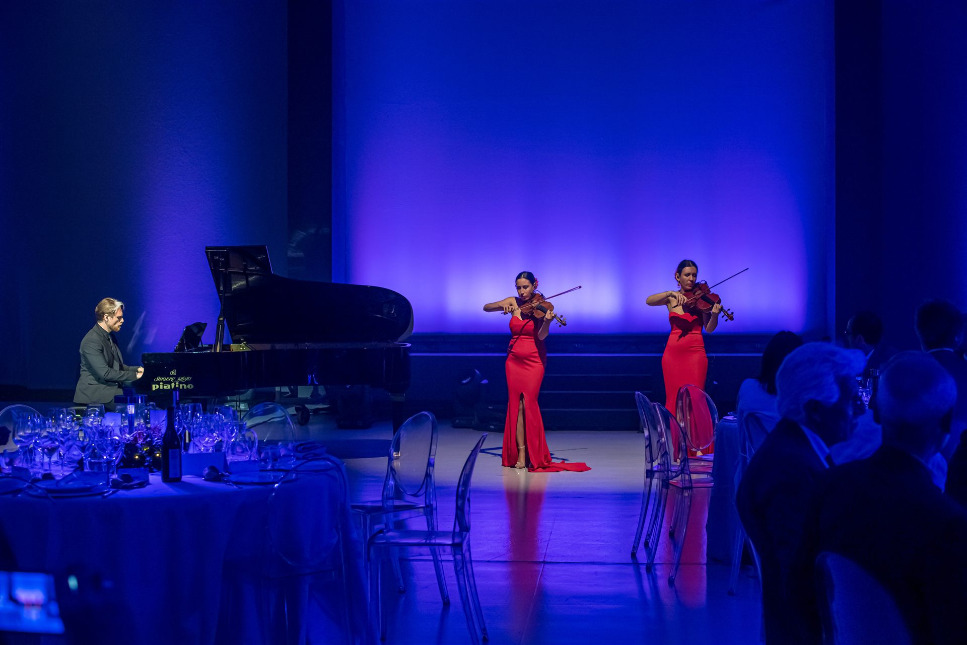 Iveco Connecting the Dots — pianista e due violiniste in abito rosso sul palco
