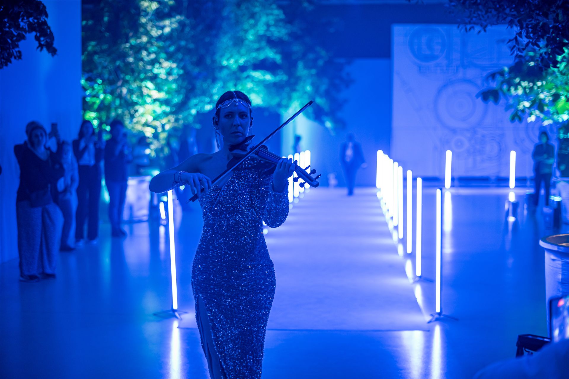 Iveco Connecting the Dots — violinista sul corridoio luminoso con chiome sullo sfondo