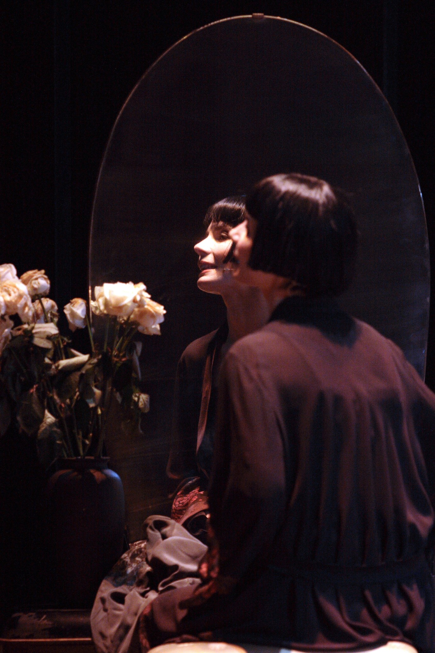 Marie Galante — Chiara Muti riflessa nello specchio ovale, vaso di rose bianche in primo piano. Foto di Corrado Maria Falsini, Teatro Nazionale Roma 2007