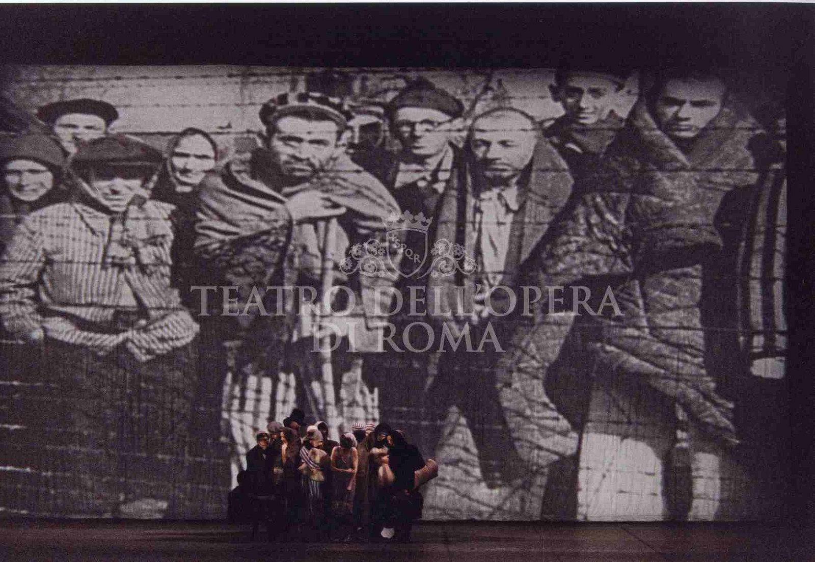 Requiem per Edith Stein &mdash; ensemble davanti alla grande proiezione del campo di concentramento, regia Beppe Menegatti, Opera Roma 2001